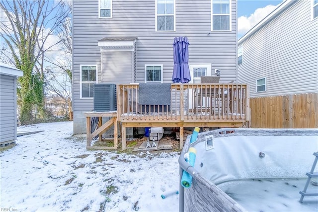 snow covered rear of property featuring a wooden deck and central air condition unit