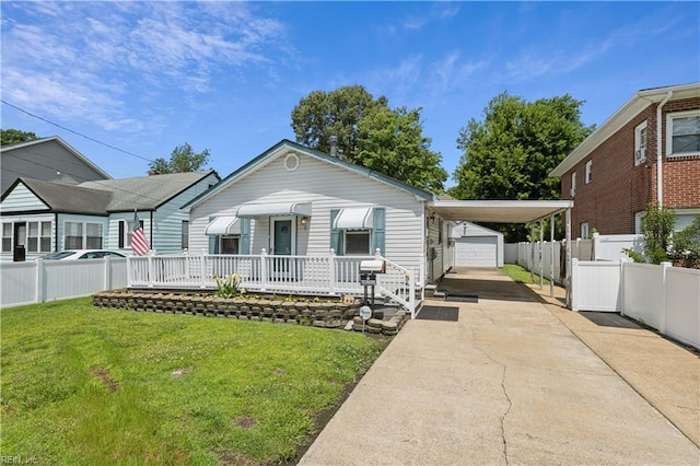 view of front of house featuring an outbuilding, a garage, a front yard, and a carport