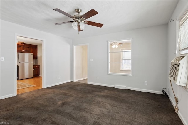 empty room with ceiling fan, plenty of natural light, and dark carpet