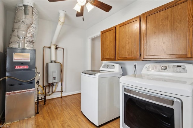 washroom with light hardwood / wood-style flooring, water heater, ceiling fan, cabinets, and washer and dryer