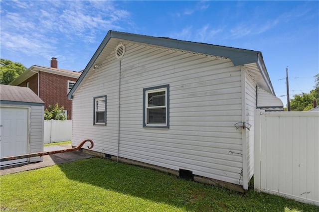 back of house featuring a yard and a shed