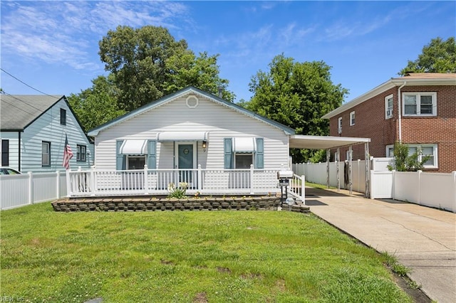 view of front of home featuring a carport, covered porch, and a front yard