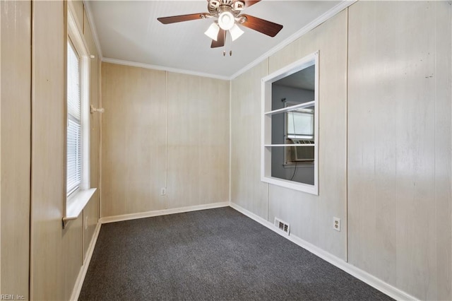 spare room with cooling unit, dark carpet, ornamental molding, and ceiling fan