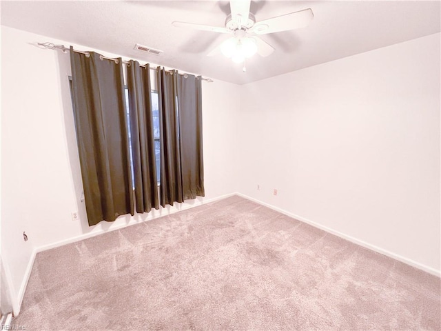 empty room featuring ceiling fan and carpet