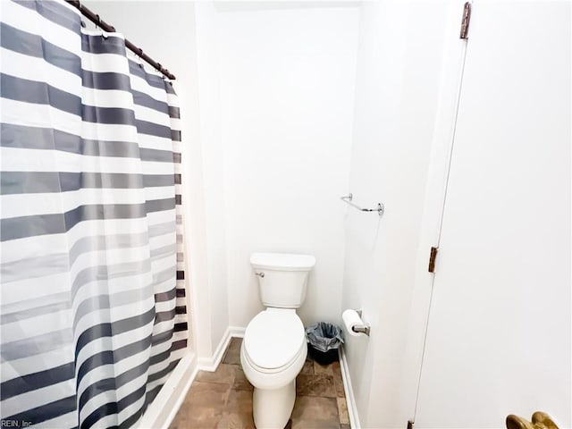 bathroom featuring toilet and a shower with shower curtain