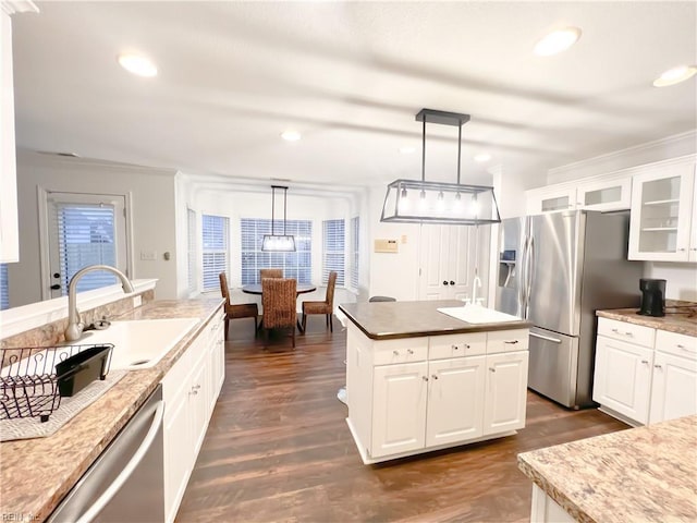 kitchen with white cabinetry, appliances with stainless steel finishes, sink, and pendant lighting