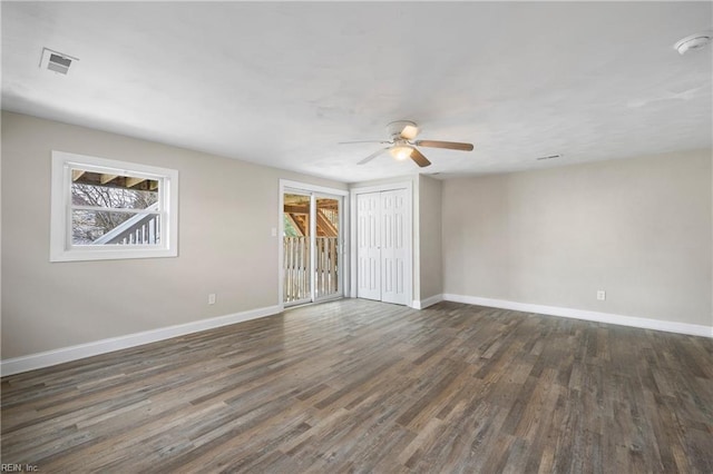 spare room featuring dark wood-type flooring and ceiling fan