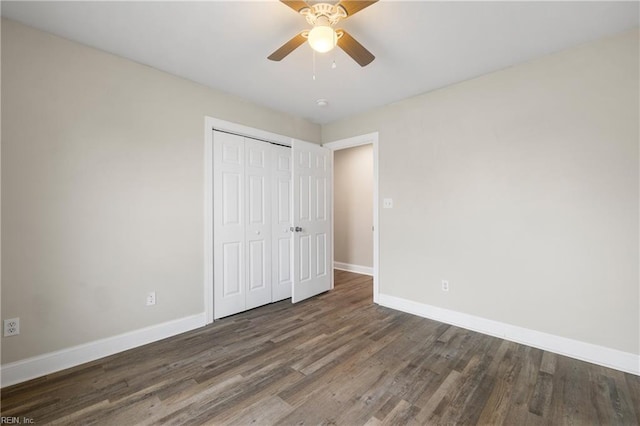 unfurnished bedroom with dark wood-type flooring, ceiling fan, and a closet