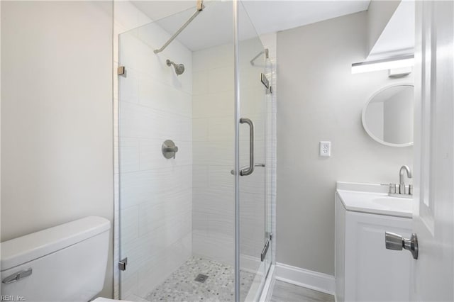 bathroom with a shower with door, vanity, and toilet