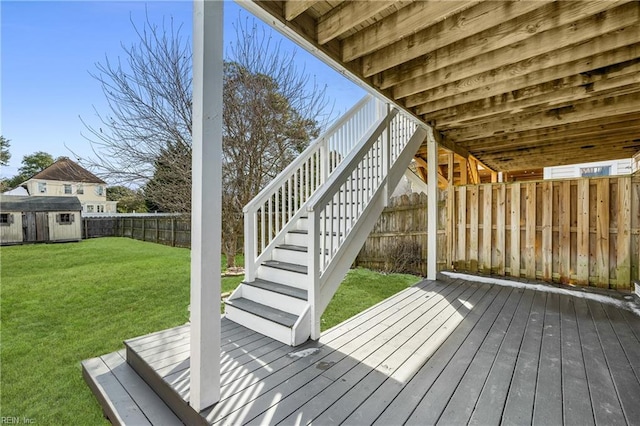 deck featuring a storage unit and a lawn