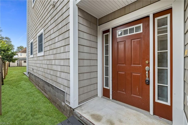 entrance to property with a lawn