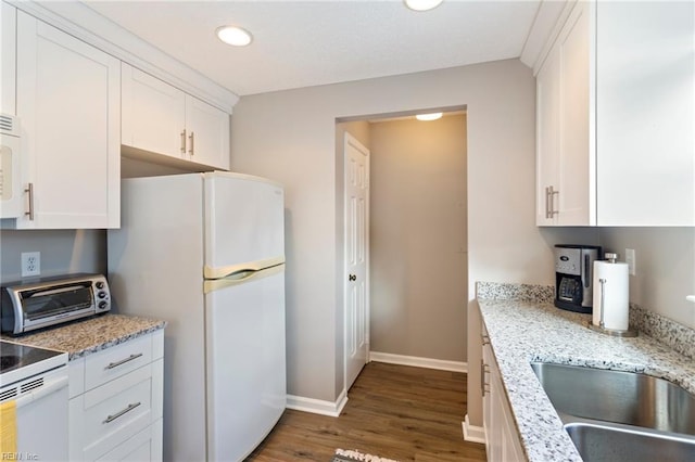 kitchen with dark wood-type flooring, sink, light stone counters, white appliances, and white cabinets