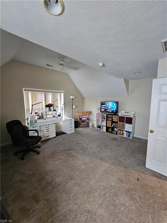 unfurnished living room with lofted ceiling, a textured ceiling, and carpet flooring