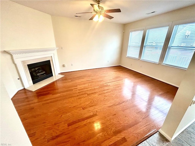 unfurnished living room with ceiling fan and hardwood / wood-style floors