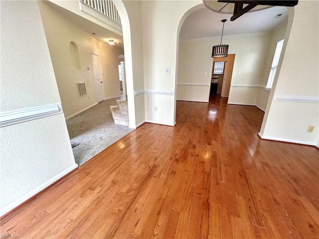 unfurnished room featuring hardwood / wood-style floors and crown molding