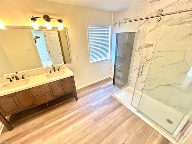 bathroom featuring wood-type flooring, walk in shower, and vanity