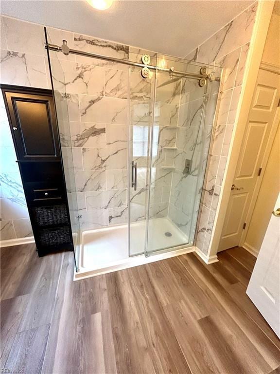 bathroom featuring hardwood / wood-style flooring and walk in shower