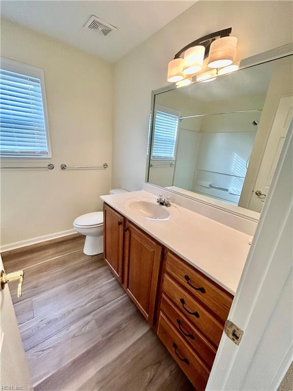 bathroom with hardwood / wood-style floors, toilet, and vanity