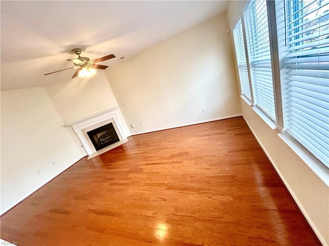 unfurnished living room featuring ceiling fan, wood-type flooring, and lofted ceiling