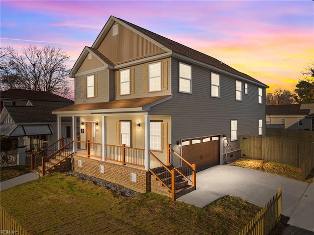 back house at dusk with a garage and covered porch