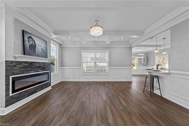 unfurnished living room featuring crown molding, dark hardwood / wood-style floors, beam ceiling, and a fireplace