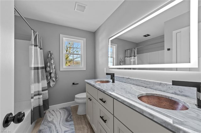 full bathroom featuring hardwood / wood-style flooring, toilet, vanity, and shower / bathtub combination with curtain