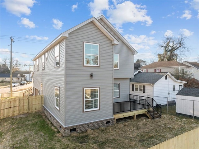 rear view of house with a wooden deck and a yard