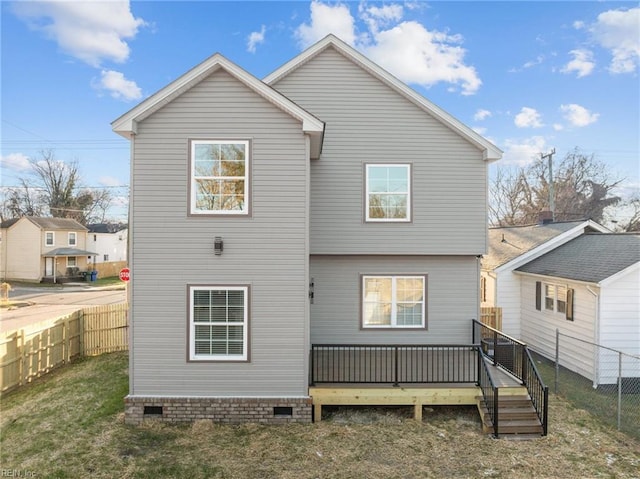 back of house with a deck and a lawn