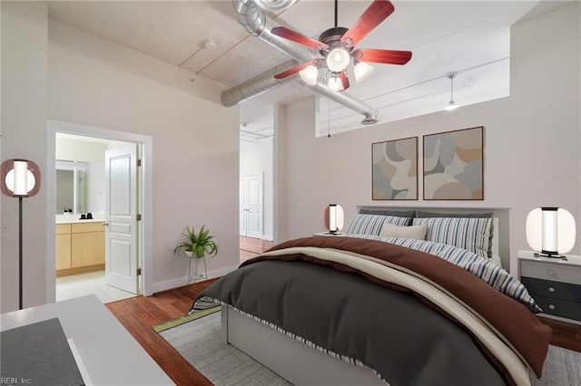 bedroom with ceiling fan, ensuite bathroom, and light hardwood / wood-style flooring