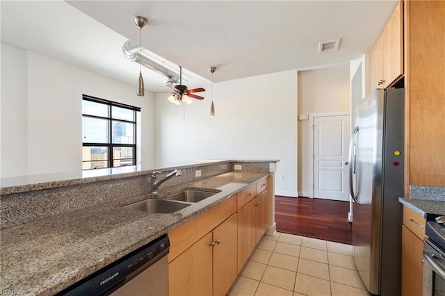 kitchen featuring stone counters, sink, light tile patterned floors, ceiling fan, and stainless steel appliances