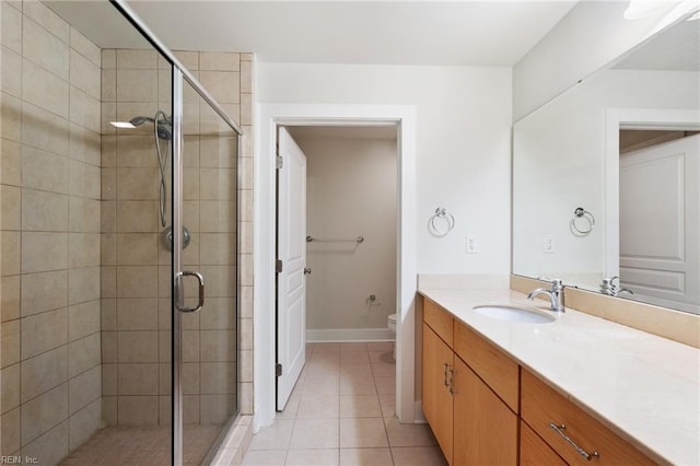 bathroom featuring vanity, toilet, a shower with door, and tile patterned flooring