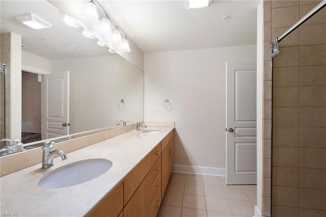 bathroom with vanity, tiled shower, and tile patterned floors