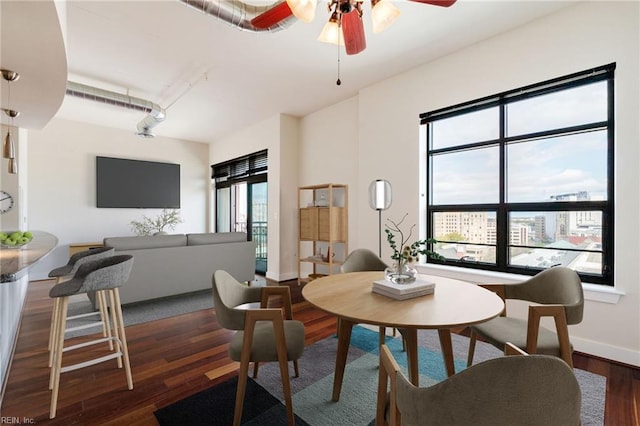 dining space with ceiling fan and dark hardwood / wood-style flooring