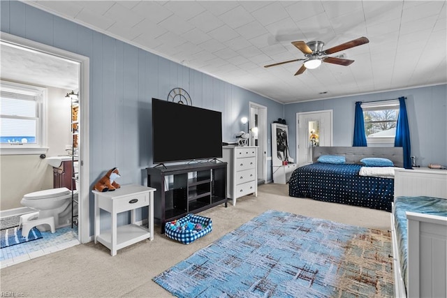 carpeted bedroom with crown molding and ceiling fan