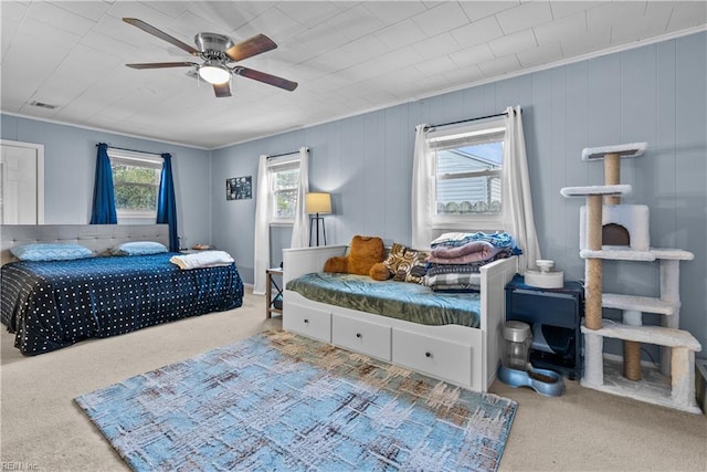 bedroom featuring carpet floors, ornamental molding, and ceiling fan