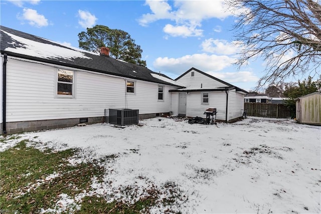 snow covered house with central air condition unit