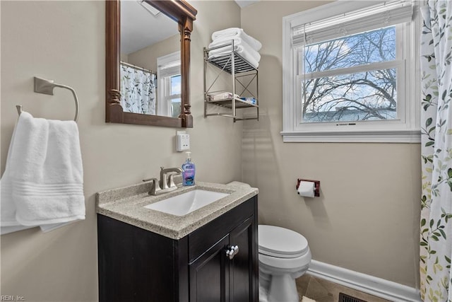 bathroom with vanity, a wealth of natural light, and toilet