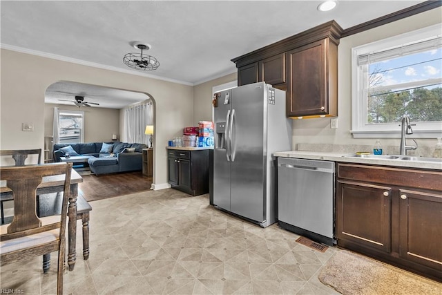 kitchen featuring appliances with stainless steel finishes, sink, ceiling fan, crown molding, and dark brown cabinets