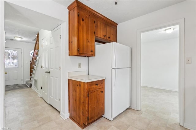 kitchen featuring white refrigerator and a textured ceiling