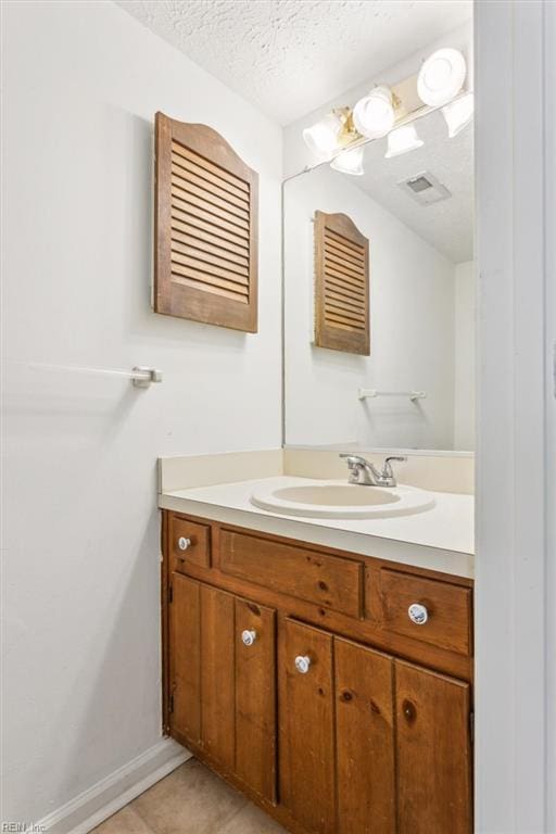 bathroom featuring vanity, tile patterned floors, and a textured ceiling