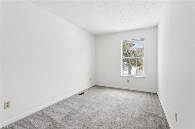 unfurnished room featuring carpet and a textured ceiling