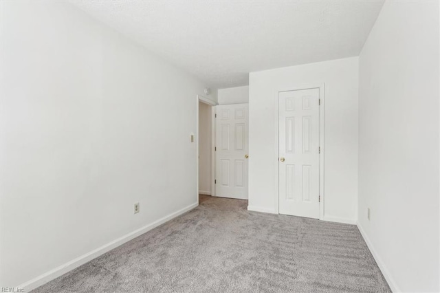 unfurnished bedroom featuring light colored carpet and a closet