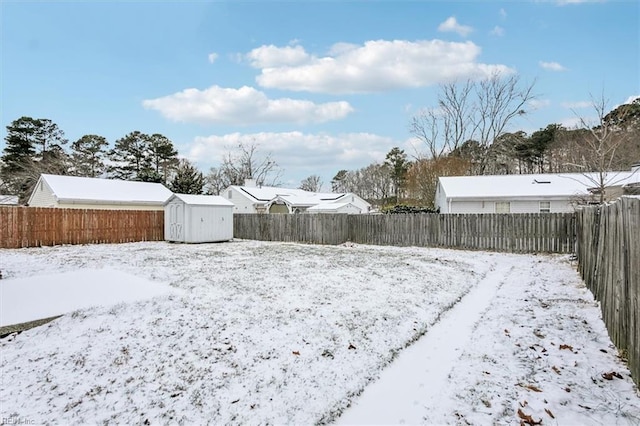 snowy yard with a storage shed