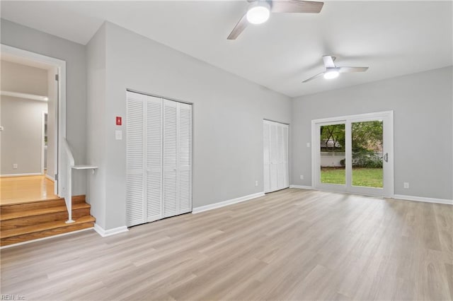 unfurnished bedroom with ceiling fan, two closets, and light wood-type flooring