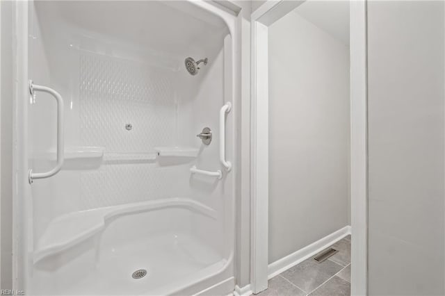 bathroom with a shower and tile patterned floors