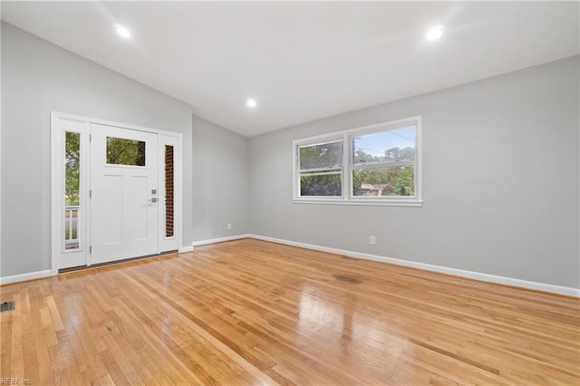 entrance foyer featuring vaulted ceiling and light hardwood / wood-style flooring