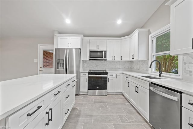 kitchen with sink, white cabinetry, decorative backsplash, and stainless steel appliances