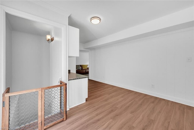 interior space with white cabinets, dark stone countertops, and light hardwood / wood-style floors