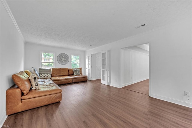 living room featuring a textured ceiling, dark hardwood / wood-style floors, and ornamental molding