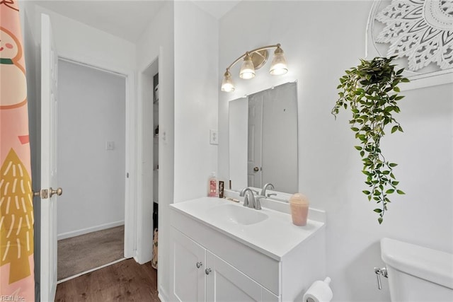 bathroom featuring hardwood / wood-style flooring, toilet, and vanity